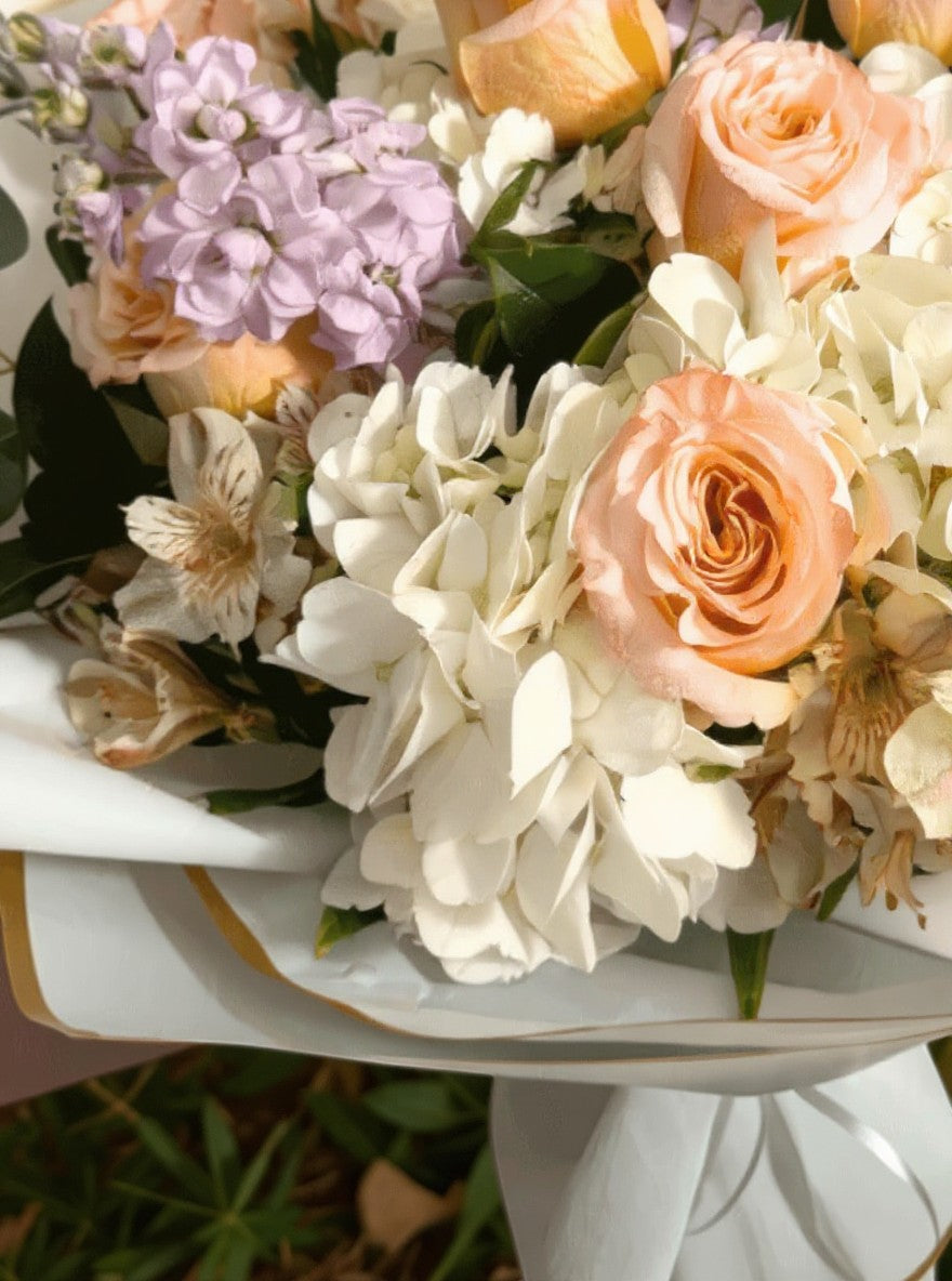 Lakewood Florist Super Blush Bouquet: peach roses, white hydrangea, lavender accents, and eucalyptus in elegant wrapping.