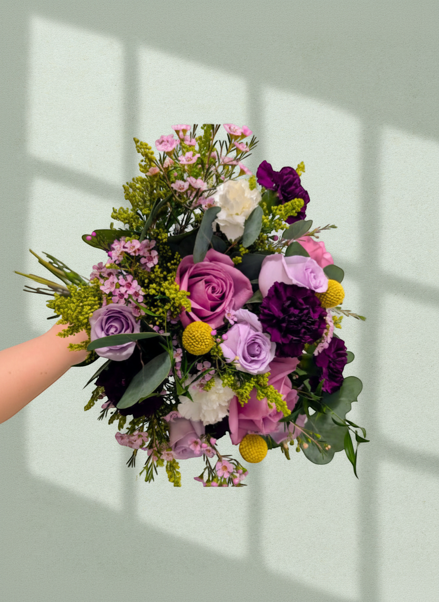 Lakewood Florist Violet Story Bouquet with purple roses, carnations, white blooms, and yellow accents.